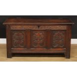 A 17th century oak blanket chest, hinged cover enclosing a till, the three panel front carved in