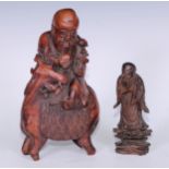 A Chinese hardwood carving, of an immoral riding on a stag 28cm high, another, elder, standing, 17.