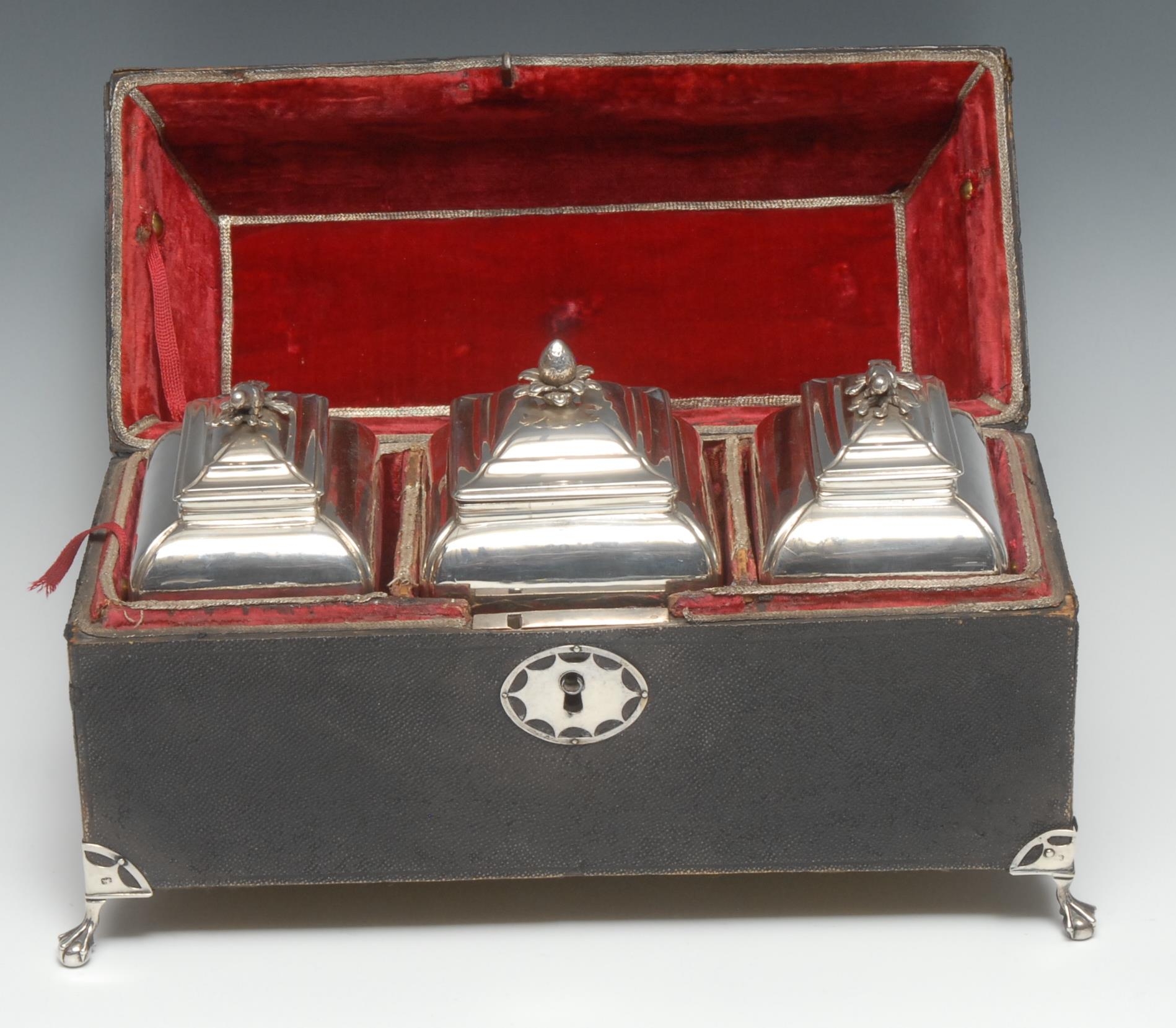 A set of three George II silver rectangular bombe shaped tea caddies, bird and fruit finials,