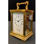 A brass carriage timepiece, Roman numerals, bevelled glass, the dial marked Woodford Est 1860