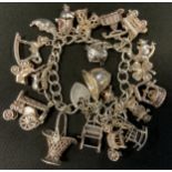 A silver charm bracelet, suspending twenty one charms inc Owl, Firemans Helmets, Pram, Rocking