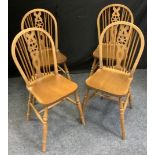 A set of four Ercol style beech wheel back side chairs, saddle seats, H-stretchers.(4)