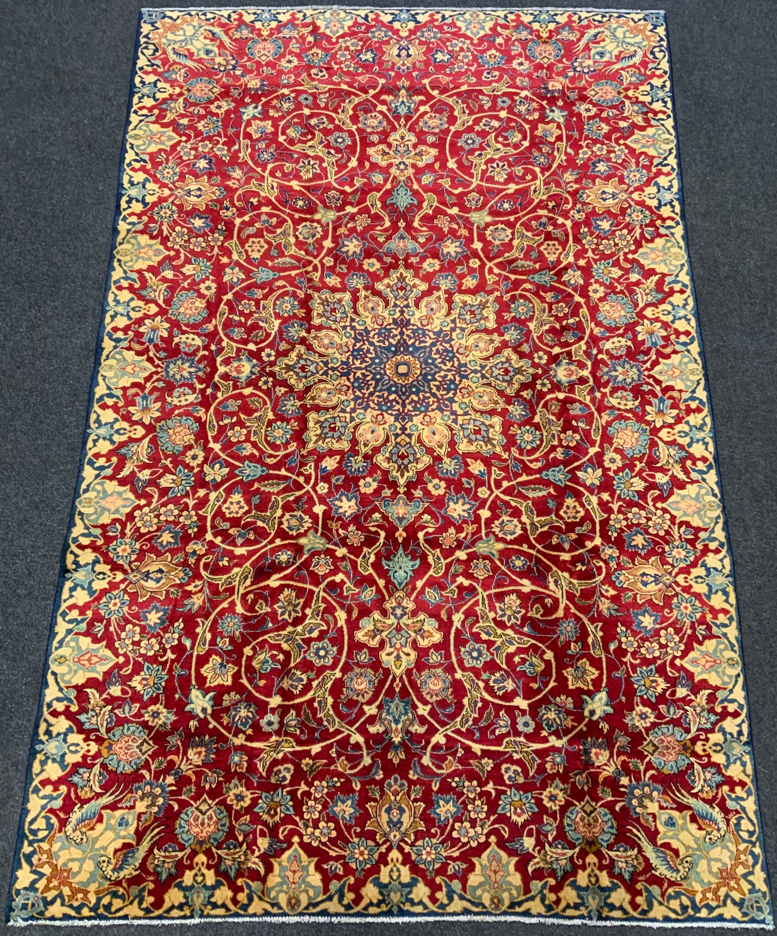 A Persian 'Ishfahan' rug / carpet, knotted in tones of pale blue, cream, and red, central lotus form