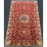 A Persian 'Ishfahan' rug / carpet, knotted in tones of pale blue, cream, and red, central lotus form