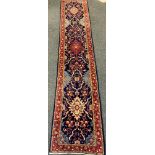 A Fine Persian hand-made Sarough runner carpet, woven in shades of pale blue, red, and indigo, 423cm