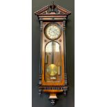 A 19th Vienna walnut wall clock, Roman numerals, twin winding holes, twin weights, glazed arched doo