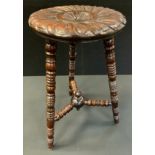 A 19th century carved oak bobbin turned stool, floral shield wheel top, turned tripod legs,