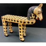 A novelty stool, in the form of a horse, painted with black spots, 55cm high