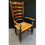 A 19th century ladder back elbow chair, shaped arms, wicker seat, turned stretcher, c.1850