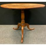 A George III oak occasional table, the circular top tilting on turned columns, tripod base, 73cm