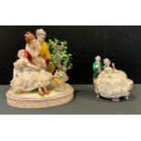 A German figure group, of a courting couple, 23cm high; another, smaller (2)