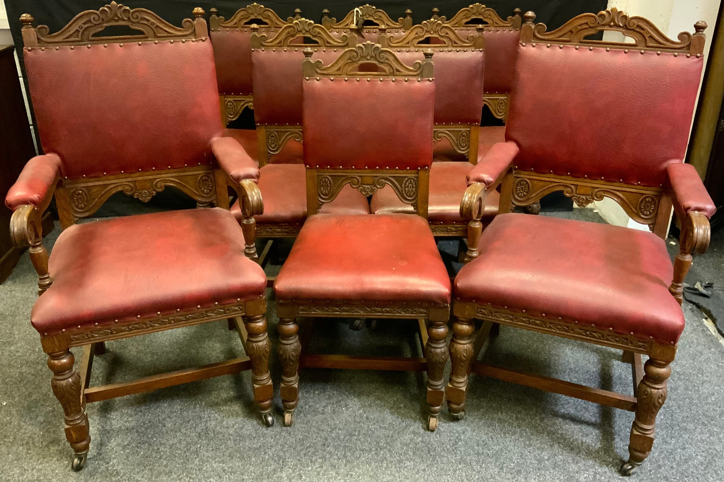 A set of eight Gothic revival oak dining chairs (six chairs and two carvers), red leather backs