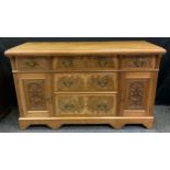 A mid 20th century walnut and burr walnut side board, three graduated long drawers to the centre,