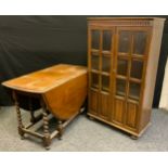 A Priory style oak side cabinet, glazed and carved linen-fold panel doors enclosing three tiers of
