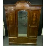 An Edwardian inlaid mahogany triple wardrobe, arched pelmet with tied Ribbon and Fruit basket inlay,