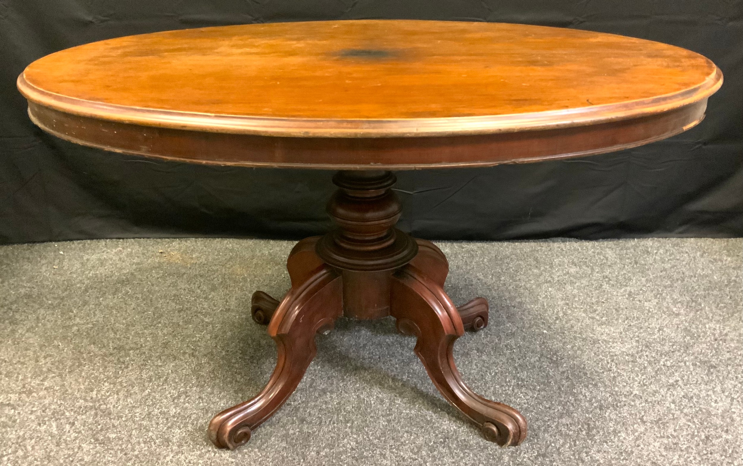 A Victorian mahogany Loo table, oval tilting top, pedestal base, carved legs, scroll feet, c.1880.