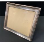 A large rectangular silver easel stand photograph frame, marks worn possibly Birmingham 1920, 26.5cm