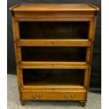 A Globe Wernicke style three tier book case, three up and over glazed doors, single base drawer,