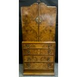 An Art Deco walnut tall boy, shaped arched two door cabinet, above four graduated drawers, stepped