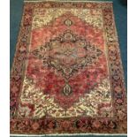 A fine hand-knotted Heriz woollen carpet, woven in muted tones of red, brown and cream, 330cm x