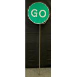 An enamel circular Stop/Go sign, red and green, 57cm diameter, rotating stick stand