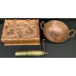 An Indian brass spice grinder; a copper hand beaten two handled Karahi; an Indonesian carved