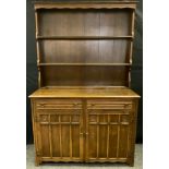 A 20th century mid oak dresser, three tier plate rack back, above pair of frieze drawers and