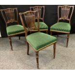 A set of four late Victorian salon chairs, pierced splats, stuffed-over seats in green striped