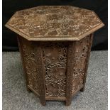 A black forest style carved oak folding table of Octagonal form, well carved leaf and fruiting