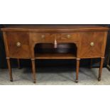 A George III style mahogany angular bow front sideboard, with central drawer, open shelf flanked