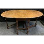 A late 19th/early 20th century oak drop-leaf dining table, oval top, turned barley-twist legs, c.