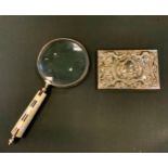 A large magnifying glass, mother of pearl and black onyx handle; a silver plated panel.