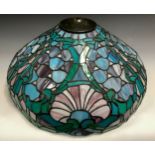 A large leaded and stained glass tiffany style lamp shade, shell and floral design in tones of blue,