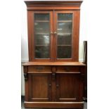 A Victorian mahogany side cabinet, moulded cornice, above two glazed doors, the projecting base,