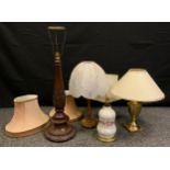 An early 20th century carved mahogany table lamp, 77cm tall; a brass urnular table lamp; others, (