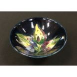 A Moorcroft Arum Lily pattern trinket dish, tube lined with flowerhead, on a blue ground, 9cm