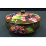 A Moorcroft Hibiscus pattern powder bowl and cover, tube lined with flowers and foliage, on a