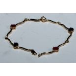 A fancy link ruby, sapphire, diamond and white stone bracelet, shaped wave bar links divided by