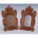 A pair of Chinese sandalwood easel photograph frames, each carved with fanciful birds, stiff leaves,