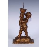 A Baroque design giltwood and gesso figural pricket candlestick, carved as a putto holding a