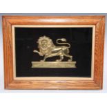 A 19th century gilt brass heraldic applique, cast as a lion passant, oak frame, 38cm x 52cm overall