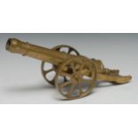 A brass model desk canon, 25cm barrel, spoked wheels, 33cm long overall