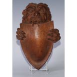 A North European mahogany boss, carved as a lion supporting a shield, 26cm x 17.5cm