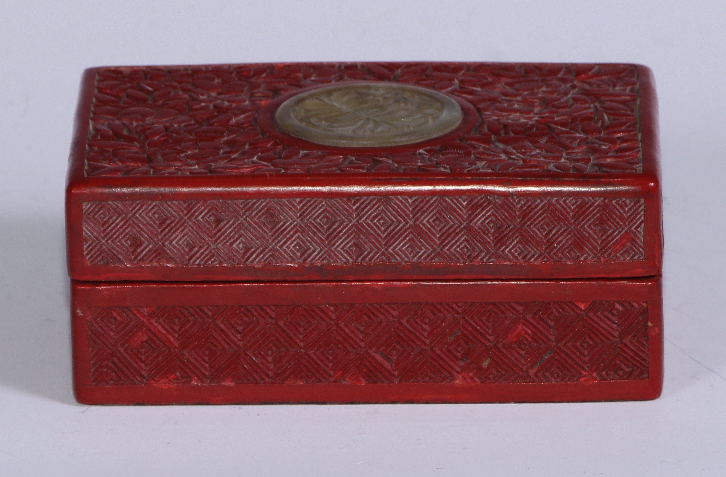 A Chinese cinnabar lacquer rectangular box, the cover centred by a carved and pierced roundel,