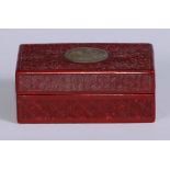 A Chinese cinnabar lacquer rectangular box, the cover centred by a carved and pierced roundel,
