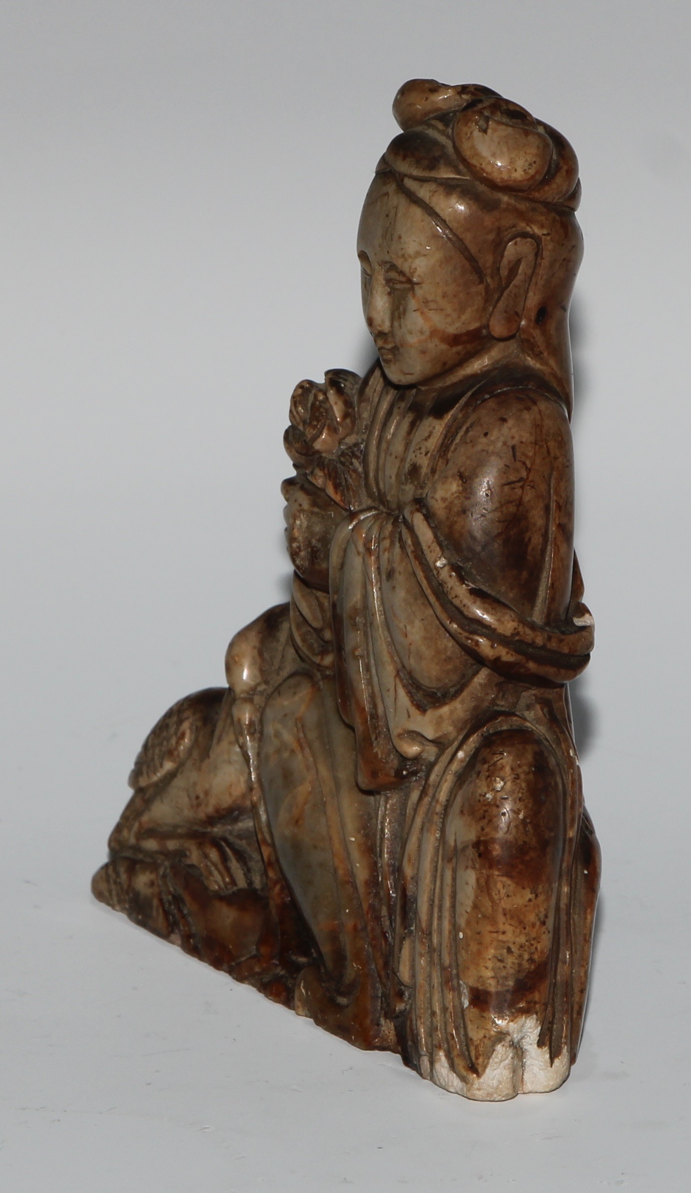 A Chinese soapstone figure, carved as guanyin, seated, serene, holding a lotus, a bird at her - Image 3 of 4