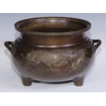 A large Chinese bronze tripod censer, cast in relief with dragons and phoenix, trellis border,