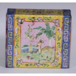 A Chinese pillow, brightly painted in polychrome enamels with deer, butterflies and flowers, on a