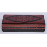 A Chinese/Siamese lacquer rounded rectangular box and cover, decorated with a lotus reserve on a