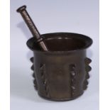 A Hispano-Moresque bronze pestle and mortar, cast in the Islamic taste with rows of geometric